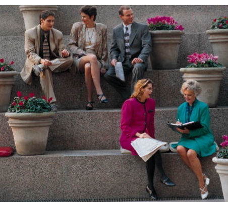 People having conversation while sitting outside on steps