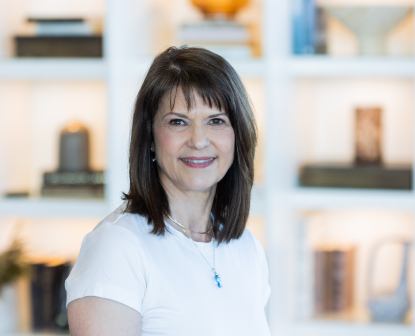 Dr. Turner wearing a white top with two necklaces smiling at camera