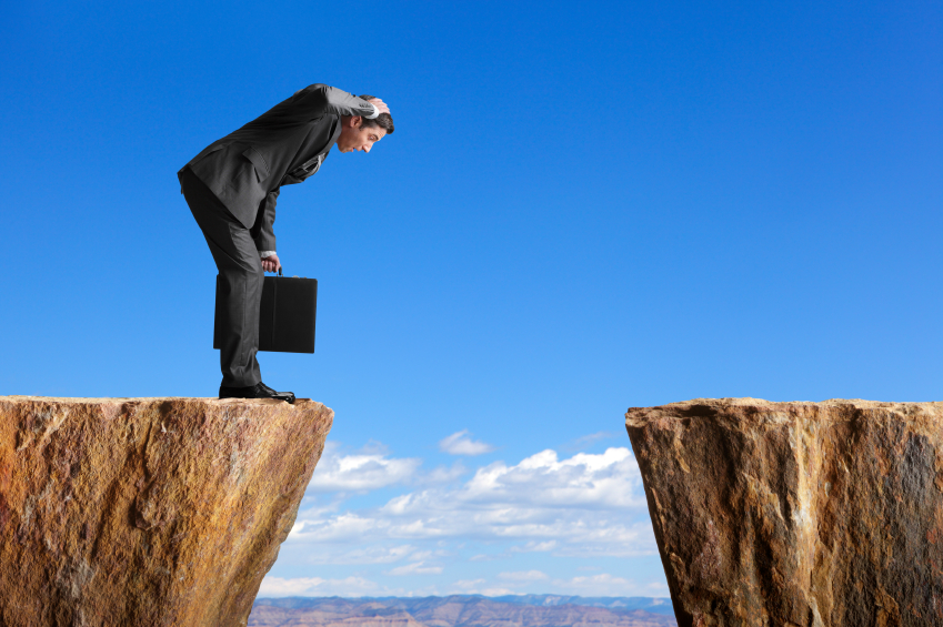 businessman looking over space between two cliffs