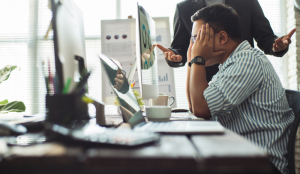 Stressed white man looking at computer screen