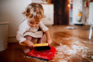 A,Small,Toddler,Girl,With,Brush,And,Dustpan,Sweeping,Floor