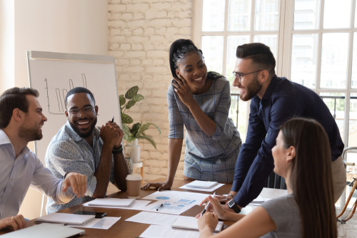 Happy and friendly multiracial business team laughing and working together at corporate