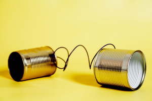 two cans tied together with string on yellow background