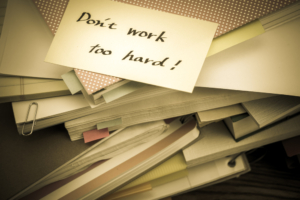 Don't work too hard, on top of pile of business documents