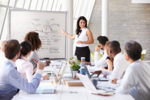 Hispanic woman leading at boardroom table